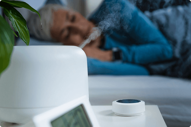 Woman sleeping in the background with a humidifier in foreground